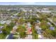 Wide aerial view shows home's location in suburban neighborhood, surrounded by mature trees and homes at 2958 Macalpin N Dr, Palm Harbor, FL 34684