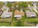 Aerial view of home with well-maintained lawn in a neighborhood with mature trees at 2958 Macalpin N Dr, Palm Harbor, FL 34684