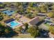 Aerial view showcases the community pool, tennis courts, shuffleboard, and lush landscaping at 2958 Macalpin N Dr, Palm Harbor, FL 34684
