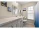 Bright bathroom features a large vanity, a toilet, and a window for natural light at 2958 Macalpin N Dr, Palm Harbor, FL 34684