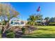 Welcome to Highland Lakes Club! Stone signage with lush landscaping and an American flag at 2958 Macalpin N Dr, Palm Harbor, FL 34684
