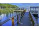 Scenic view of a wooden dock leading to boat slips on a tranquil lake with lush vegetation at 2958 Macalpin N Dr, Palm Harbor, FL 34684