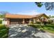 Charming single-story home featuring a brick facade, attached two-car garage, and well-maintained lawn at 2958 Macalpin N Dr, Palm Harbor, FL 34684