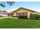 Charming home with a well-manicured lawn, brick accents, and an attached garage at 2958 Macalpin N Dr, Palm Harbor, FL 34684