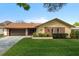 Charming home with a well-manicured lawn, brick accents, and an attached garage at 2958 Macalpin N Dr, Palm Harbor, FL 34684