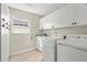 Well-lit laundry room features white cabinets, a window, a sink, and a washer/dryer at 2958 Macalpin N Dr, Palm Harbor, FL 34684