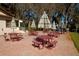 Community picnic area features tables with red metal frames and striped umbrellas, inviting outdoor gatherings at 2958 Macalpin N Dr, Palm Harbor, FL 34684