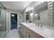 Elegant bathroom featuring double sinks, neutral cabinets and direct access to the pool area at 3036 Rainbow Ct, Safety Harbor, FL 34695