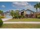 Inviting single-Gathering home with lush landscaping, mature palm trees, and brick accents at 3036 Rainbow Ct, Safety Harbor, FL 34695