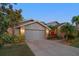 Charming single-story home with a well-manicured lawn and a two car garage at twilight at 3036 Rainbow Ct, Safety Harbor, FL 34695