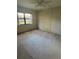 A bedroom with carpet, a large window overlooking outside, and a ceiling fan at 3046 Eastland Blvd # J106, Clearwater, FL 33761