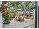Backyard patio with dining table and chairs, set amid mature trees and landscaping at 3520 Poplar Ne St, St Petersburg, FL 33704