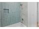 A modern bath features blue tile surround, a built-in soap niche and white, neutral counters at 3520 Poplar Ne St, St Petersburg, FL 33704