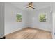 Well-lit bedroom with wood floors, two windows, and a ceiling fan at 3520 Poplar Ne St, St Petersburg, FL 33704