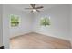 Light and bright bedroom offers wood floors, neutral paint, a ceiling fan and two windows at 3520 Poplar Ne St, St Petersburg, FL 33704
