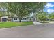 Beautifully landscaped home featuring a lush green lawn, mature trees, and charming front porch at 3520 Poplar Ne St, St Petersburg, FL 33704