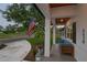 Charming front porch view showcasing an American flag, comfortable seating, and lovely landscaping at 3520 Poplar Ne St, St Petersburg, FL 33704