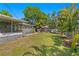 Expansive backyard with mature landscaping, a charming shed, and an inviting screened-in porch at 3822 W Euclid Ave, Tampa, FL 33629