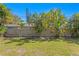 Beautiful backyard featuring a privacy fence, lush trees, tropical foliage, and manicured lawn at 3822 W Euclid Ave, Tampa, FL 33629