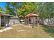 Backyard shed with a front porch, swing, and paver patio area in a well-maintained yard at 3822 W Euclid Ave, Tampa, FL 33629
