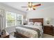 Inviting bedroom with wooden furniture, ceiling fan, and two windows at 3822 W Euclid Ave, Tampa, FL 33629
