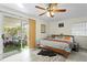 Relaxing bedroom featuring a sliding door to a screened patio, ceiling fan, and wood-look floors at 3822 W Euclid Ave, Tampa, FL 33629