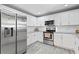 Galley kitchen features stainless steel appliances, white cabinets, and granite countertops at 3822 W Euclid Ave, Tampa, FL 33629