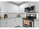 Close-up of kitchen with stainless steel appliances, white cabinets, and granite countertops at 3822 W Euclid Ave, Tampa, FL 33629