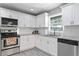 Well-lit kitchen features white cabinets, stainless steel appliances, and modern fixtures at 3822 W Euclid Ave, Tampa, FL 33629