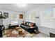 Cozy living room with a leather sofa, patterned rug, and natural light from multiple windows at 3822 W Euclid Ave, Tampa, FL 33629