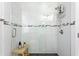 Modern shower enclosed with glass, featuring sleek white subway tiles and a black accent row at 3822 W Euclid Ave, Tampa, FL 33629