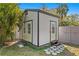 Outdoor storage shed with double doors, single door, and small stepping stone pathway in the backyard at 3822 W Euclid Ave, Tampa, FL 33629
