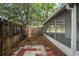 Landscaped backyard with a screened porch and a gate leading to additional outdoor space at 402 Abigail Rd, Plant City, FL 33563