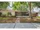 Charming home featuring a screened porch, a brick walkway, and lush landscaping at 402 Abigail Rd, Plant City, FL 33563