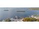 A picturesque aerial view of the waterfront with a dock, boat storage, and modern waterfront houses surrounded by trees at 455 Alt 19 S Hwy # 81, Palm Harbor, FL 34683