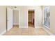 Neutral colored bedroom with tile floor, a window, and doorways to closet and bathroom at 455 Alt 19 S Hwy # 81, Palm Harbor, FL 34683