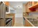 Cozy kitchen showcasing wood cabinets and tile flooring that continues into the adjacent living area at 455 Alt 19 S Hwy # 81, Palm Harbor, FL 34683