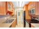 Practical kitchen featuring wood cabinetry, double sink, and modern appliances at 455 Alt 19 S Hwy # 81, Palm Harbor, FL 34683