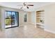 Airy living room with tile flooring, built-in shelving, and sliding glass doors at 455 Alt 19 S Hwy # 81, Palm Harbor, FL 34683