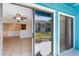 View from the sliding doors to the bright living space and a partial view of the kitchen at 455 Alt 19 S Hwy # 81, Palm Harbor, FL 34683