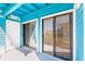 View of blue patio with sliding glass doors and white door leading to the interior of the home at 455 Alt 19 S Hwy # 81, Palm Harbor, FL 34683