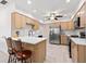 Open kitchen with bar seating, stainless steel appliances, and light wood cabinets at 4806 Bay Crest Dr, Tampa, FL 33615