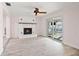 Cozy living room with a brick fireplace, ceiling fan, tile floors, and sliding glass doors at 4806 Bay Crest Dr, Tampa, FL 33615