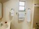 Functional bathroom featuring a vanity, mirror, and shower with patterned wallpaper at 4904 E River Hills Dr, Tampa, FL 33617
