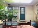 Inviting front entrance with a teal door, surrounded by lush greenery and a covered porch at 4904 E River Hills Dr, Tampa, FL 33617