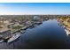 An aerial view showcases a waterfront community with canals, private docks, and boats under a clear blue sky at 5401 Leeward Ln, New Port Richey, FL 34652