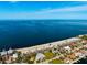 Stunning aerial view of coastal homes, a sandy beach, and beautiful turquoise water on a sunny day at 5401 Leeward Ln, New Port Richey, FL 34652