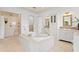Bathroom with a soaking tub, walk-in shower, double sink vanity, and tile floors at 608 Orange Ave, Clearwater, FL 33756