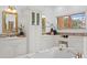 A light and airy bathroom with a soaking tub, double vanity, and built-in storage at 608 Orange Ave, Clearwater, FL 33756