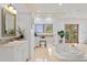 Spacious bathroom featuring a soaking tub, double sink vanity, natural light, and tiled floors at 608 Orange Ave, Clearwater, FL 33756